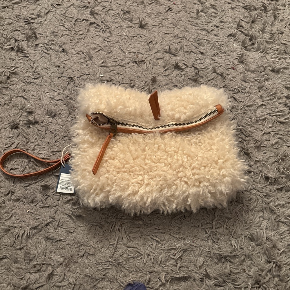 Cream and tan faux fur clutch bag with zipper closure and wrist strap